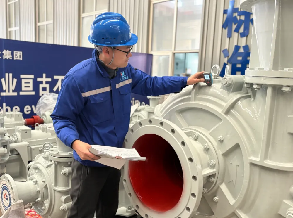 Engineer inspecting the ceramic wet end of an SAZP pump, liner visible through the inlet flange